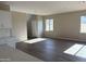 Bright living room with wood-look floors and large windows, open to the kitchen and stairs to the upper level at 3363 S 180Th Ln, Goodyear, AZ 85338