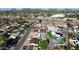 Extensive aerial view showcases houses with swimming pools, a highway nearby, and lush trees surrounding the area at 3444 E Paradise Dr, Phoenix, AZ 85028