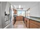 Bright kitchen offering stainless steel refrigerator, wood cabinets, and backyard views at 3444 E Paradise Dr, Phoenix, AZ 85028