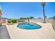 A beautiful kidney-shaped pool is surrounded by concrete, lush greenery, and a tall palm tree at 3444 E Paradise Dr, Phoenix, AZ 85028