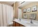 This bathroom features a double sink, framed mirror, bathtub, and framed artwork at 35414 N 32Nd Dr, Phoenix, AZ 85086