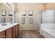 Bright bathroom featuring a double vanity sink, framed mirrors, and a shower-tub combo at 35414 N 32Nd Dr, Phoenix, AZ 85086
