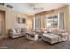 Comfortable living room with plush sofas, a ceiling fan, and lots of natural light from large windows at 35414 N 32Nd Dr, Phoenix, AZ 85086