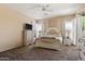Spacious bedroom boasts a ceiling fan, a large bed, an ensuite bath, and plentiful natural light at 35414 N 32Nd Dr, Phoenix, AZ 85086