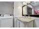 Bright bathroom features marble countertops, vanity with chrome faucet and white cabinets, and a laundry area with modern washer/dryer at 3551 N 12Th St # 101, Phoenix, AZ 85014