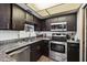 A functional kitchen featuring stainless steel appliances, dark cabinetry, and granite countertops at 3551 N 12Th St # 101, Phoenix, AZ 85014