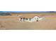 Wide view of back desert home featuring covered patio, neutral stucco, and desert landscaping at 37504 W Elm Ave, Tonopah, AZ 85354