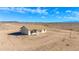 Rear exterior view of desert home, neutral stucco, desert landscaping, and covered patio at 37504 W Elm Ave, Tonopah, AZ 85354