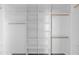 Walk-in closet with custom white shelving and wooden closet rods at 37504 W Elm Ave, Tonopah, AZ 85354