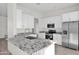 Spacious kitchen with white cabinets, granite island, and stainless appliances at 37504 W Elm Ave, Tonopah, AZ 85354