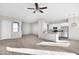 Bright, open-concept living area with wood floors, ceiling fan, and white kitchen at 37504 W Elm Ave, Tonopah, AZ 85354