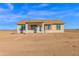 Rear exterior of the home features a covered patio and a large, open backyard at 37504 W Elm Ave, Tonopah, AZ 85354