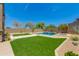 Spacious backyard showcasing artificial turf, desert landscaping, and a luxurious pool and spa area at 3804 E Daley Ln, Phoenix, AZ 85050