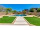 Picturesque backyard with artificial turf, custom pool and spa with fire bowls, and desert landscaping at 3804 E Daley Ln, Phoenix, AZ 85050