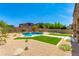 Expansive backyard with desert landscaping, vibrant artificial turf, and a sparkling pool with fire bowls at 3804 E Daley Ln, Phoenix, AZ 85050