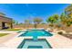 Backyard featuring a stunning custom pool with a spa, rock detail, a water feature, and lush landscaping at 3804 E Daley Ln, Phoenix, AZ 85050