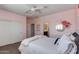 This bedroom boasts soft pink walls, a full bed, a white faux fur blanket, and ample natural light at 3804 E Daley Ln, Phoenix, AZ 85050