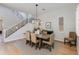 Elegant dining room featuring a wooden table, upholstered chairs, and stairs with iron spindles at 3804 E Daley Ln, Phoenix, AZ 85050