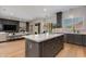 Bright, open kitchen with gray cabinets, a central island, and hardwood floors blending into the living area at 3804 E Daley Ln, Phoenix, AZ 85050