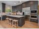 A modern kitchen featuring gray cabinets, stainless steel appliances, and a central island with barstool seating at 3804 E Daley Ln, Phoenix, AZ 85050