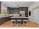 A modern kitchen with gray cabinets, stainless steel appliances, and a quartz countertop island with three stools at 3804 E Daley Ln, Phoenix, AZ 85050