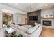 Bright living room with a built-in gray entertainment center, a marble fireplace, and a neutral-toned sectional at 3804 E Daley Ln, Phoenix, AZ 85050