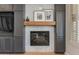 Elegant living room with a gray built-in entertainment center, a marble fireplace, and shuttered windows at 3804 E Daley Ln, Phoenix, AZ 85050