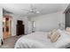 Bright main bedroom with white linens, ceiling fan, dresser, and ensuite at 3804 E Daley Ln, Phoenix, AZ 85050