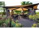 Outdoor seating area with awning and stone pillars surrounded by desert plants at 3804 E Daley Ln, Phoenix, AZ 85050