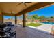 Inviting covered patio features a ceiling fan, lounge area, and views of the sparkling pool and landscaped backyard at 3804 E Daley Ln, Phoenix, AZ 85050