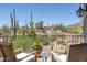 Relaxing balcony with desert views, wooden chairs, and black iron railing perfect for enjoying the outdoors at 41916 N 101St N Pl, Scottsdale, AZ 85262