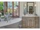 Bathroom featuring a vintage-style tub, vanity with marble countertop, and views of the lush outdoors at 41916 N 101St N Pl, Scottsdale, AZ 85262