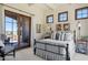 Bedroom with a wrought iron bed, dark-trimmed windows and doors, and access to an outdoor patio at 41916 N 101St N Pl, Scottsdale, AZ 85262
