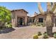 Beautiful desert home featuring a circular brick driveway, desert landscaping and an arched entry at 41916 N 101St N Pl, Scottsdale, AZ 85262