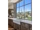 Farmhouse kitchen featuring a large window, white marble countertops, and custom wood cabinetry at 41916 N 101St N Pl, Scottsdale, AZ 85262