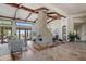 Spacious living room featuring high, beamed ceilings, wood floors, stone fireplace, and outdoor access at 41916 N 101St N Pl, Scottsdale, AZ 85262