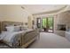 Bright main bedroom featuring a king bed, stone fireplace, seating area, and access to the outdoors at 41916 N 101St N Pl, Scottsdale, AZ 85262