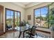 Home office with a glass-top desk, wood floors, and a wall of windows showcasing desert landscaping at 41916 N 101St N Pl, Scottsdale, AZ 85262