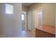 Hallway with tile floor, window and views to a carpeted room, a door and a built-in desk at 42360 W Abbey Rd, Maricopa, AZ 85138