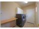 Well-equipped laundry room featuring modern washer and dryer set, ample cabinets, and workspace at 42360 W Abbey Rd, Maricopa, AZ 85138