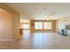 Spacious living room featuring tile floors, large windows, and seamless flow into the dining and kitchen areas at 42360 W Abbey Rd, Maricopa, AZ 85138