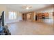 Open concept living room flowing into a well-equipped kitchen, showcasing the tile flooring and natural lighting at 42360 W Abbey Rd, Maricopa, AZ 85138