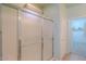 Modern bathroom shower with glass door, tiled walls, and adjacent access to walk-in closet at 42360 W Abbey Rd, Maricopa, AZ 85138