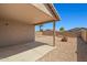 A covered back patio with a built-in firepit surrounded by gravel creating a cozy outdoor space at 43938 W Colby Dr, Maricopa, AZ 85138