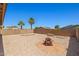 A spacious backyard features neutral gravel, a firepit and privacy wall with well-maintained landscaping at 43938 W Colby Dr, Maricopa, AZ 85138