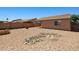 Enjoy outdoor living in this gravel backyard featuring a stone water feature and a covered patio at 43938 W Colby Dr, Maricopa, AZ 85138