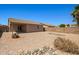 A xeriscaped backyard with a covered patio and decorative rock feature adds to the charm of this home at 43938 W Colby Dr, Maricopa, AZ 85138