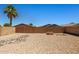 The xeriscaped backyard offers a low maintenance yard with a decorative rock feature and privacy wall at 43938 W Colby Dr, Maricopa, AZ 85138