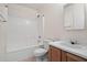 Clean, functional bathroom with white tiled shower/tub, wooden vanity, and essential fixtures at 43938 W Colby Dr, Maricopa, AZ 85138