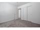 Clean bedroom showcasing neutral carpet, white walls, closet, and ample natural light at 43938 W Colby Dr, Maricopa, AZ 85138